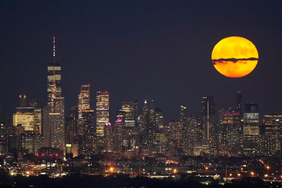 FILE - The moon rises through clouds over the skyline of lower Manhattan in this view from West Orange, N.J., Tuesday, Aug. 1, 2023, during a supermoon period. (AP Photo/Seth Wenig, File)