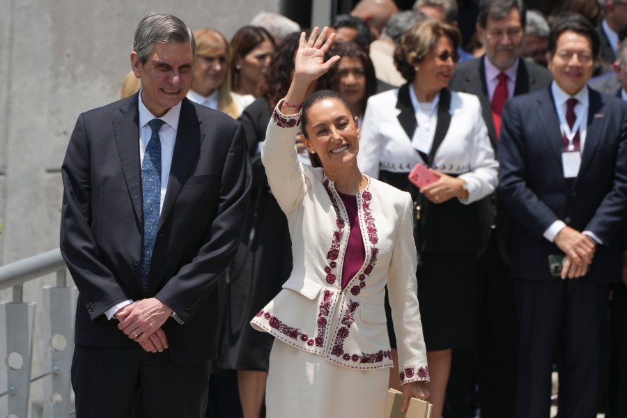 Mexican President-elect Claudia Sheinbaum, accompanied by husband Jesus Maria Tarriba, waves as she leaves a ceremony certifying her as the winner of the presidential election, at the Federal Electoral Tribunal in Mexico City, Thursday, Aug. 15, 2024. (AP Photo/Fernando Llano)