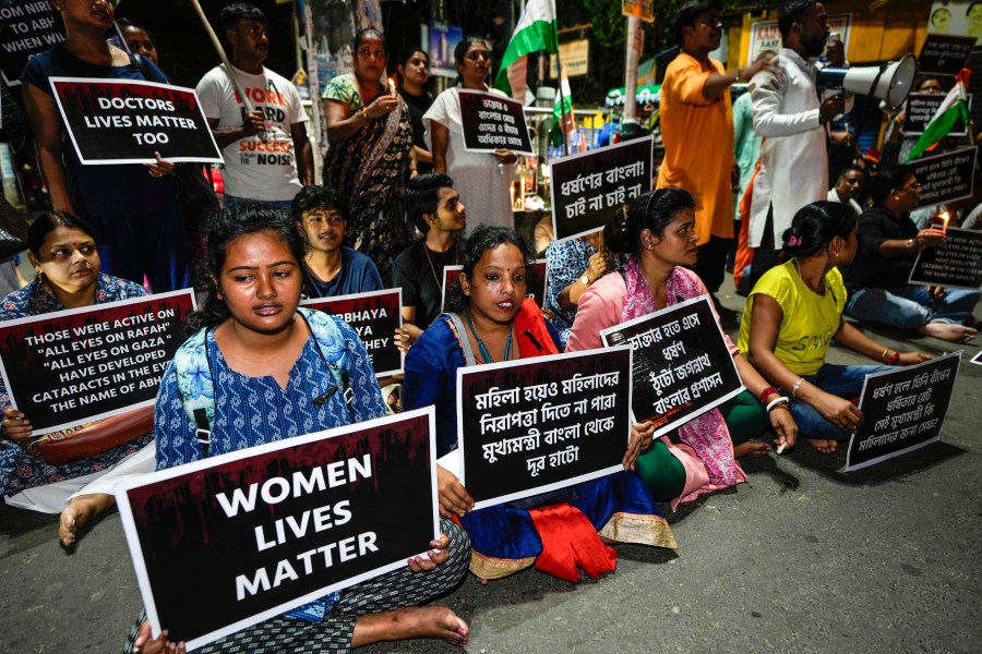 Protesters join in a midnight rally protesting against the murder of a 31 year old post-graduate trainee demanding proper investigation in Kolkata, India, Wednesday, Aug. 14, 2024. (AP Photo/Bikas Das)