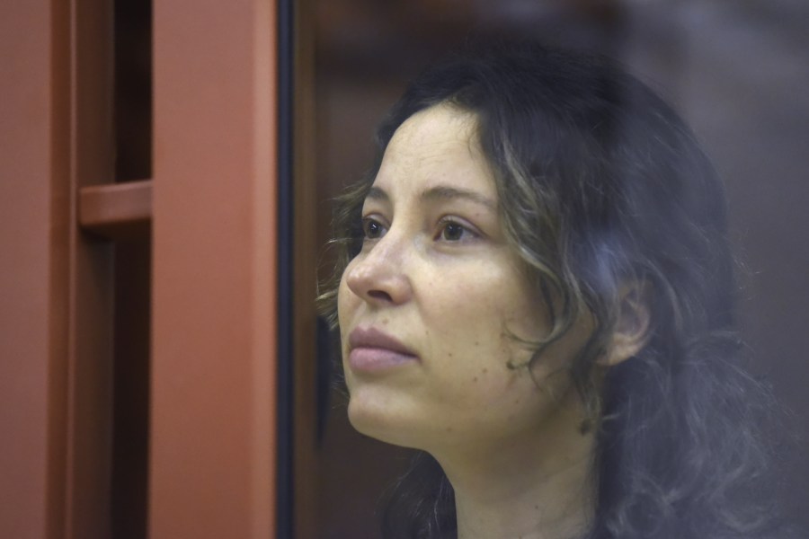 Ksenia Karelina, also known as Khavana sits in a glass cage in a court room in Yekaterinburg, Russia, Thursday, Aug. 15, 2024. A Russian court on Thursday sentenced U.S.-Russian dual national Ksenia Khavana to 12 years in prison on a treason conviction for allegedly raising money for the Ukrainian military. (AP Photo)