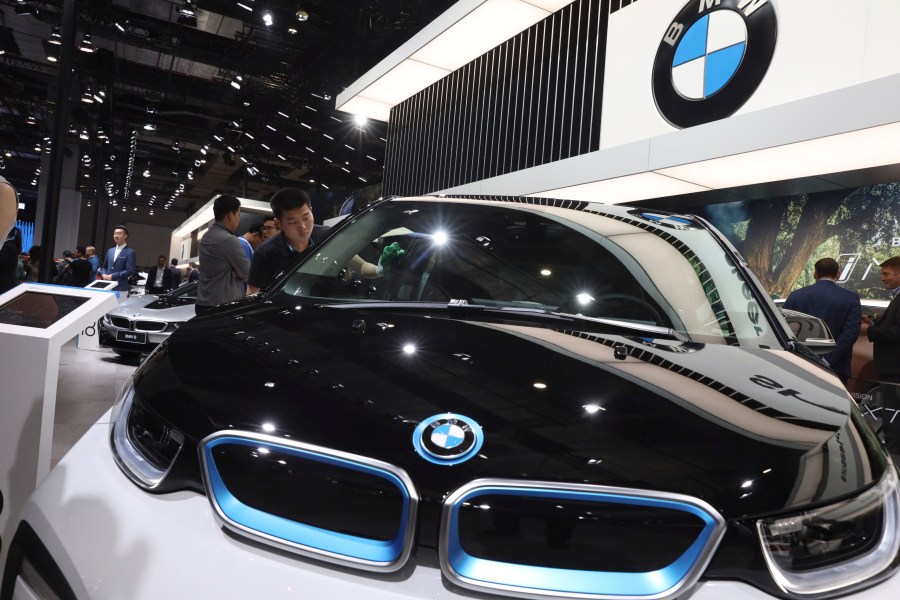 FILE -A worker cleans an electric vehicle at the BMW booth during the Auto Shanghai 2019 show in Shanghai on April 17, 2019. (AP Photo/Ng Han Guan, file)