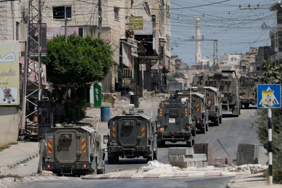 A column of Israeli Army armored vehicles leave following a military operation in the West Bank town of Tubas, Wednesday, Aug. 14, 2024. (AP Photo/Majdi Mohammed)