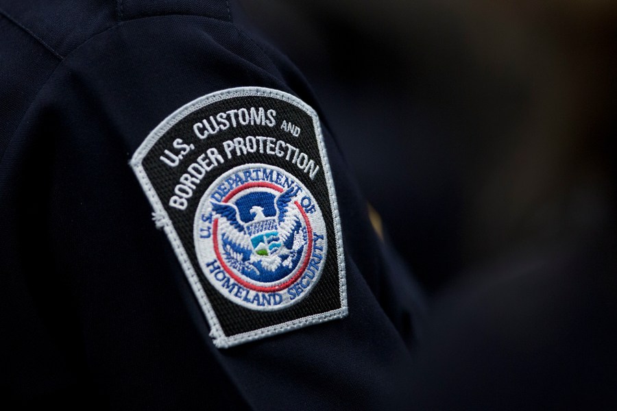 FILE - A customs agent wears a patch for the U.S. Customs and Border Protection agency, Oct. 27, 2017, at John F. Kennedy International Airport in New York. (AP Photo/Mark Lennihan, file)