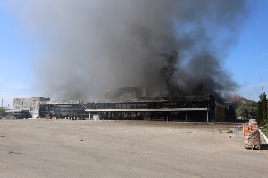 Smoke rises from a burned out shopping center after the shelling that Russian officials in Donetsk said was conducted by Ukrainian forces, in Donetsk, Russian-controlled Donetsk region, eastern Ukraine, Friday, Aug. 16, 2024. (AP Photo/Alexei Alexandrov)