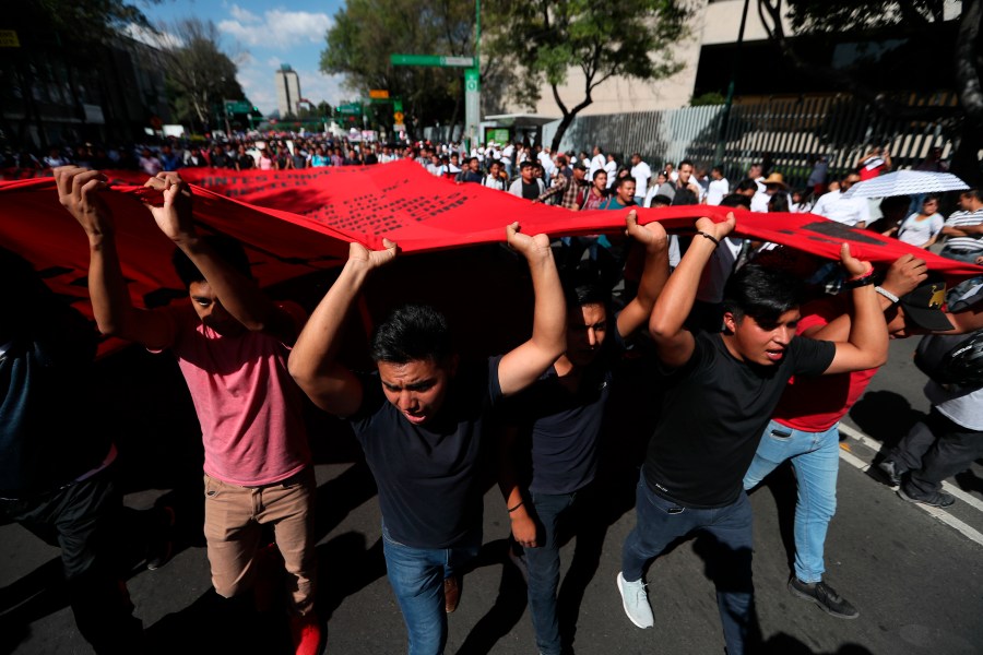 Demonstrators march in remembrance of the 1968 Tlatelolco student massacre, an event considered part of the Mexico's "dirty war" when the government used its forces to suppress political opposition in Mexico City, Oct. 2, 2019. (AP Photo/Fernando Llano)