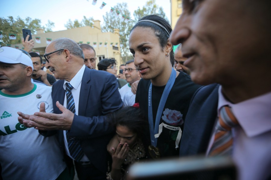 Olympic gold medalist in the the women's 66 kg boxing Algeria's Imane Khelif, center, smiles as she arrives home after returning from the 2024 Paris Olympic Games in Tiaret, Algeria, Friday, Aug. 16, 2024. (AP Photo/Anis Belghoul)