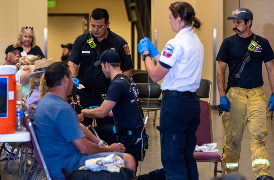 Members of the Colorado Springs Fire Department and AMR paramedics treat people for heat-related illness at the Pikes Peak Regional Airshow on Saturday, Aug. 17, 2024 in Colorado Springs, Colo. (Parker Seibold/The Gazette via AP)