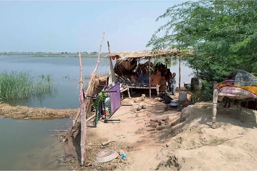 A family take refuge on high place after flooding their house and area caused by heavy monsoon rains near Sohbat Pur, an area of Pakistan's southwestern Baluchistan province, Monday, Aug. 19, 2024. (AP Photo)