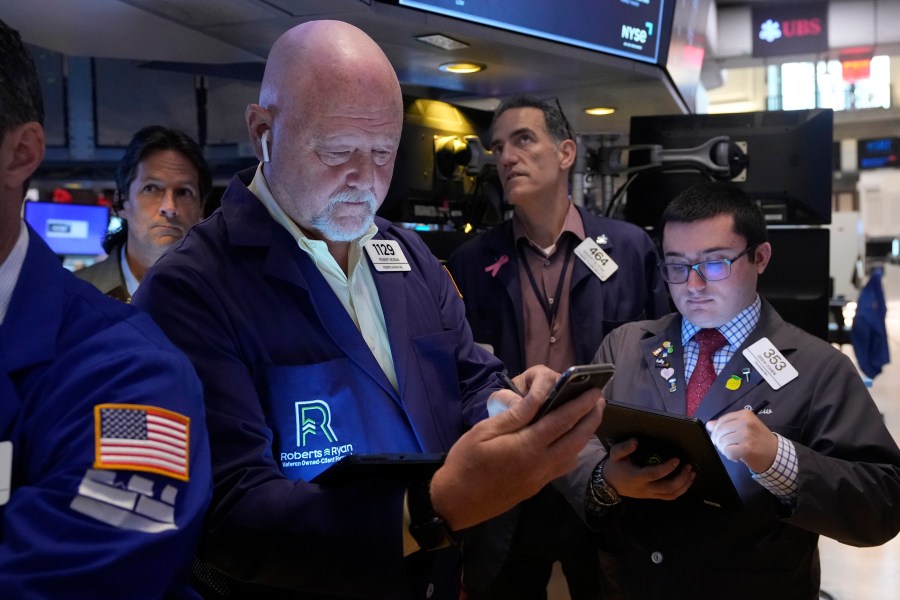 FILE - Robert Moran, left, works with fellow traders on the floor of the New York Stock Exchange, Friday, Aug. 16, 2024. (AP Photo/Richard Drew, File)