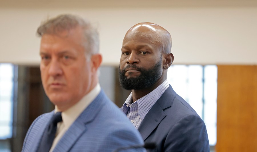 Former NFL football player Gosder Cherilus, right, stands, Monday, Aug. 19, 2024, near defense attorney Brian Sullivan, left, during his arraignment on charges including disorderly conduct, in East Boston Municipal Court, in Boston. (Pat Greenhouse/The Boston Globe via AP, Pool)