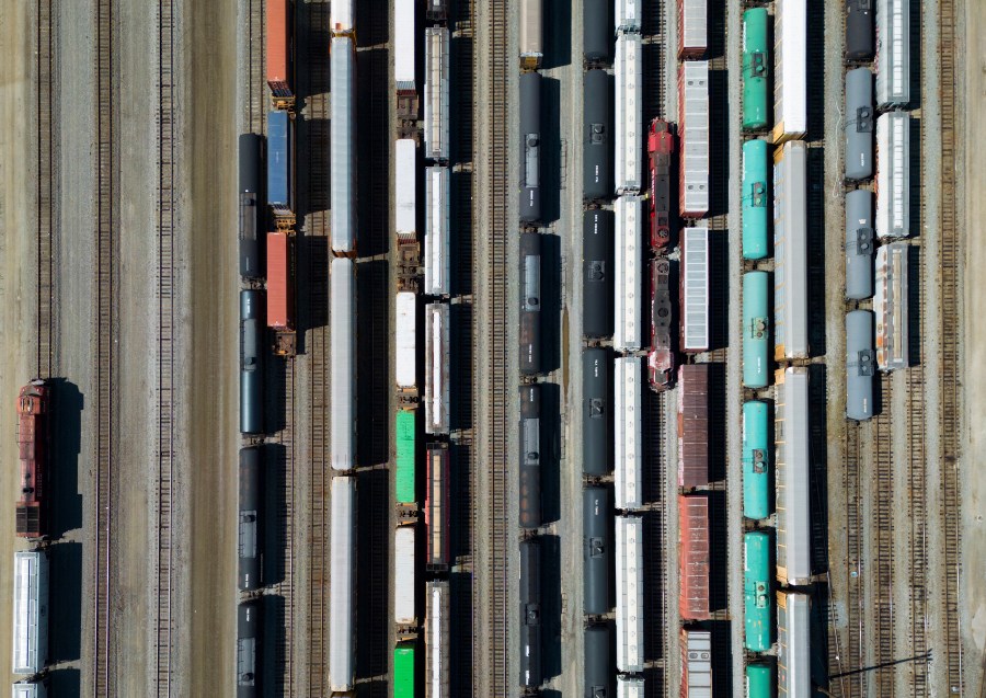 Employees move locomotives, right, as rail and tanker cars and shipping containers sit idle at the Canadian Pacific Kansas City (CPKC) rail yard in Port Coquitlam, British Columbia, Monday, Aug. 19, 2024. (Darryl Dyck/The Canadian Press via AP)