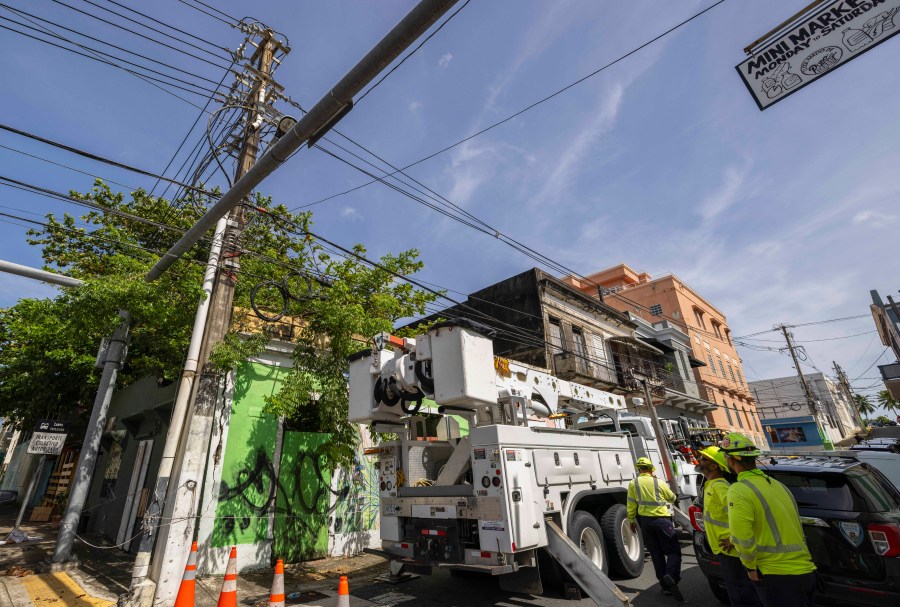 Electric workers carry out repairs in the community of Puerta de Tierra after the passage of Tropical Storm Ernesto in San Juan, Puerto Rico, Thursday, Aug. 15, 2024. (AP Photo/Alejandro Granadillo)