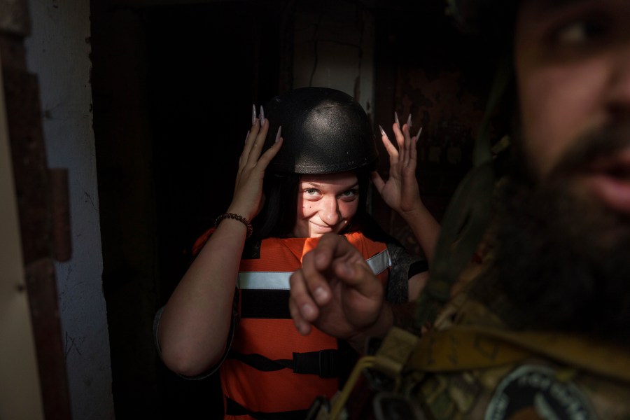 Sofia Zhuravleva, 14, wears a helmet as she is evacuated with her mother Maryna Scherbyna and 9 year old brother Bohdan Scherbyna, as local people are moved from Selidove to safe areas, in Pokrovsk, Donetsk region, Ukraine, on Tuesday, Aug. 20, 2024. (AP Photo/Evgeniy Maloletka)