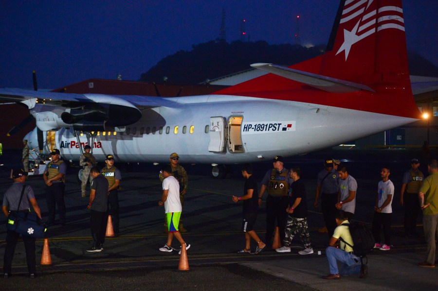 Colombian migrants walk in handcuffs and shackles to a plane for deportation at Marcos A. Gelabert de Albrook Airport in Panama City, Tuesday, Aug. 20, 2024. (AP Photo/Agustin Herrera)