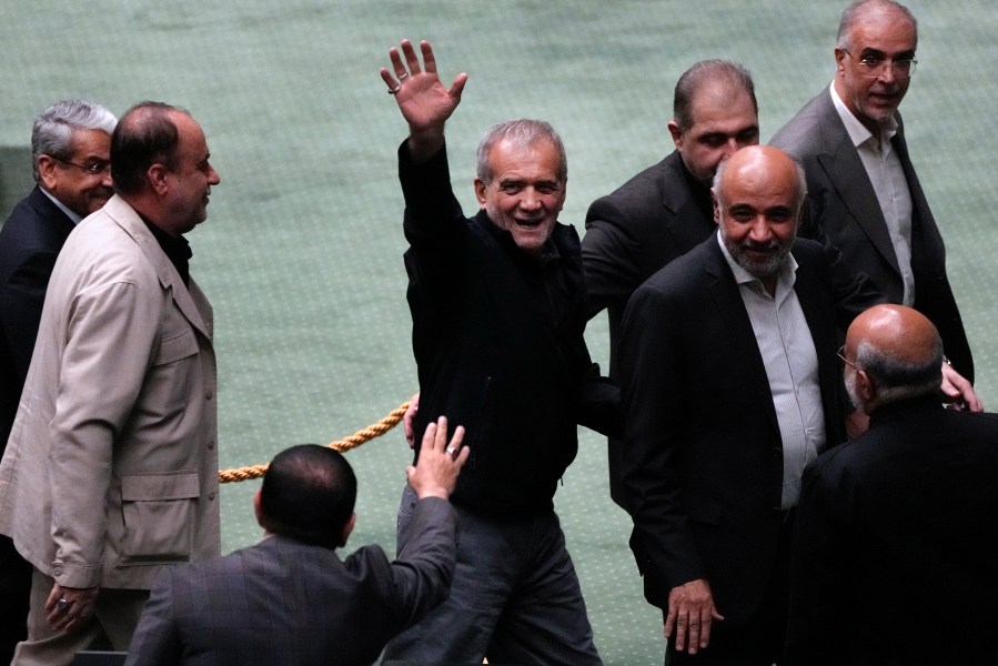 Iranian President Masoud Pezeshkian waves to the lawmakers while leaving the parliament after the conclusion of his speech during the debate on his proposed ministers, in Tehran, Iran, Wednesday, Aug. 21, 2024. (AP Photo/Vahid Salemi)