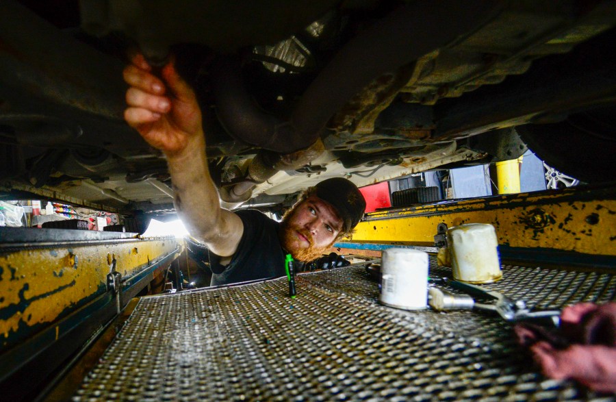 FILE - Ian Frank, a pit technician at Stop & Go on Putney Road in Brattleboro, Vt., changes the oil on a vehicle on July 15, 2024. (Kristopher Radder/The Brattleboro Reformer via AP, File)