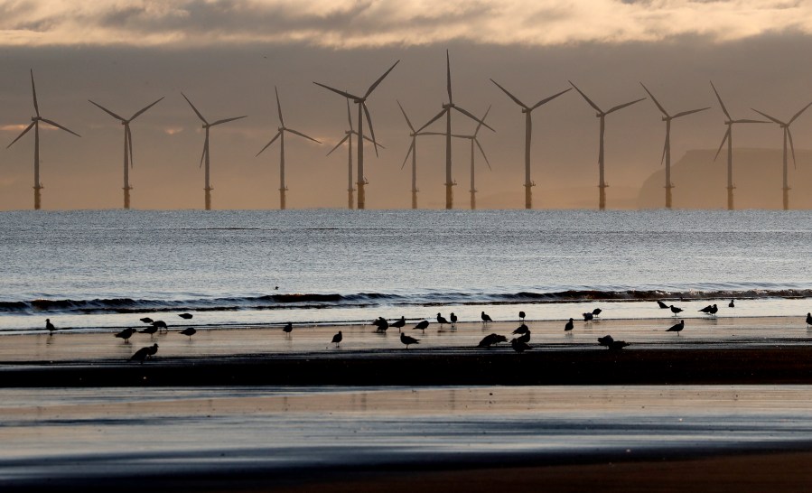 FILE - An offshore wind farm is visible from the beach in Hartlepool, England, Nov. 12, 2019. (AP Photo/Frank Augstein, File)