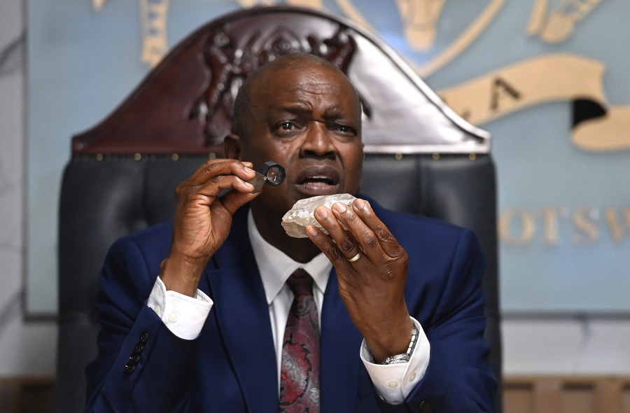 Botswana's President Mokgweetsi Masisi holds the 2,492-carat diamond that was unearthed at one of its mines and will be put on show, Thursday, Aug. 22, 2024, in Gaborone. (AP Photo)