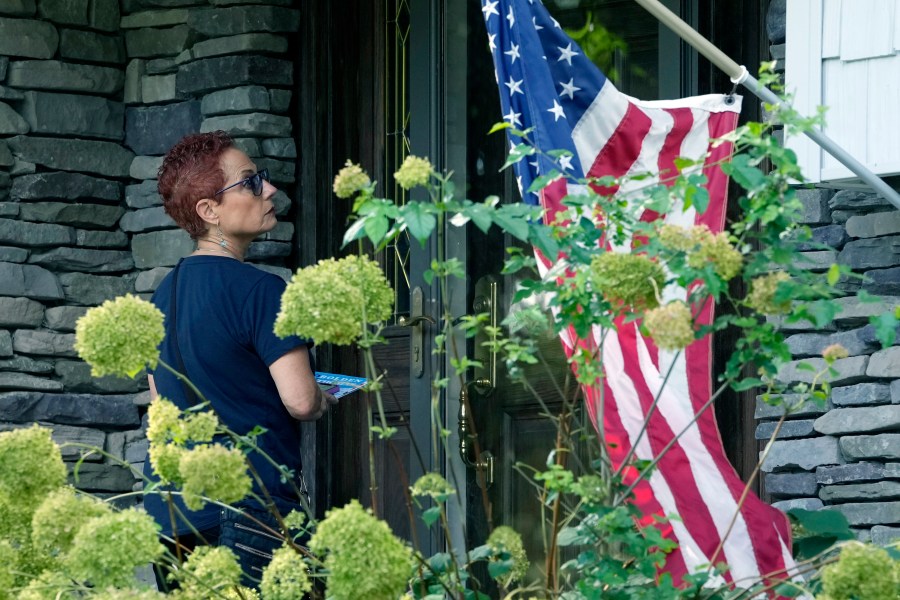 Marcie Paul, chair of the group Fems for Dems, stops at a residence, Wednesday, Aug. 21, 2024, in West Bloomfield, Mich. (AP Photo/Carlos Osorio)