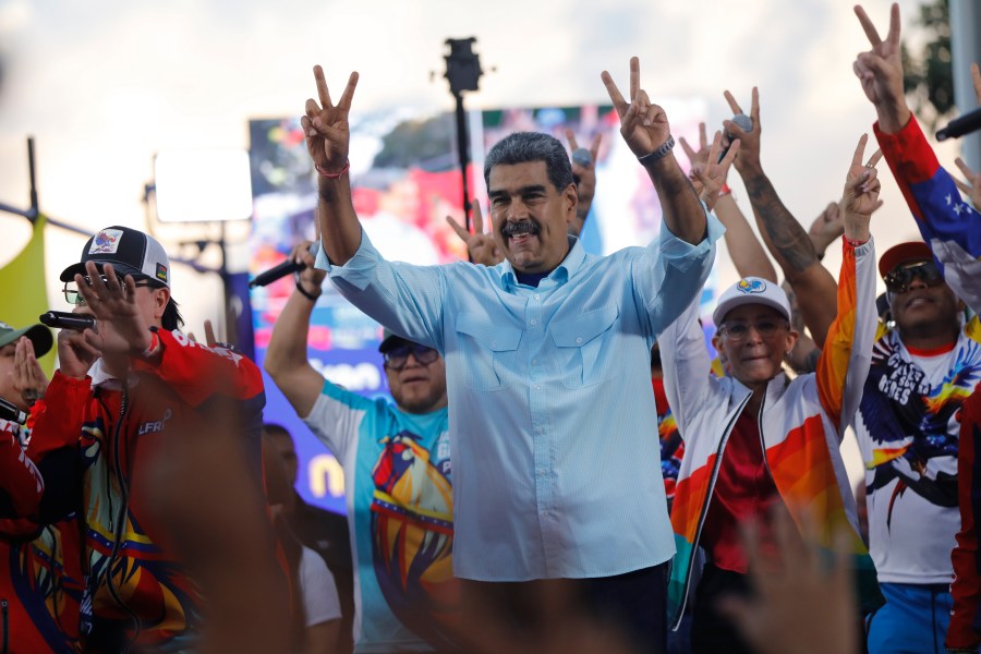 Venezuelan President Nicolas Maduro flashes victory hand signs at supporters during a pro-government rally, in Caracas, Venezuela, Saturday, Aug. 17, 2024. (AP Photo/Cristian Hernandez )