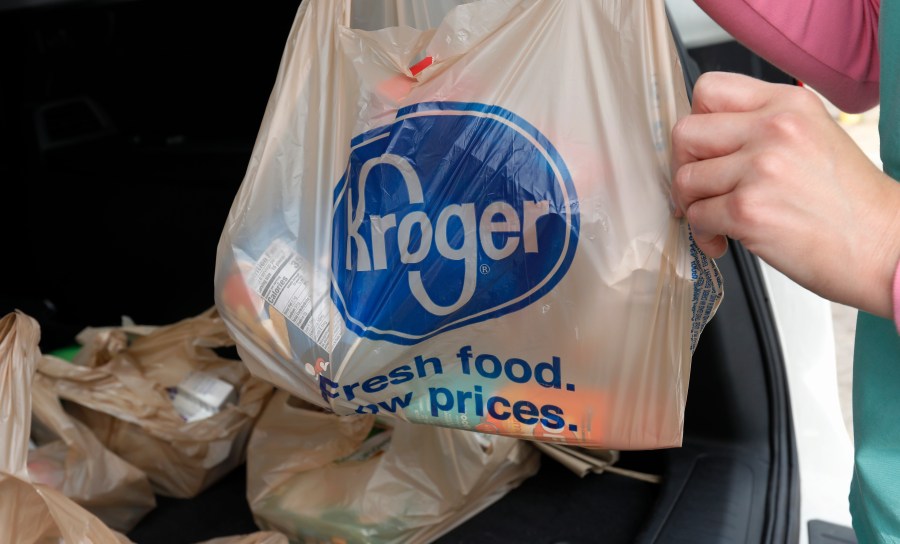 FILE - A customer moves purchases at a Kroger grocery store in Flowood, Miss., June 26, 2019. (AP Photo/Rogelio V. Solis, File)