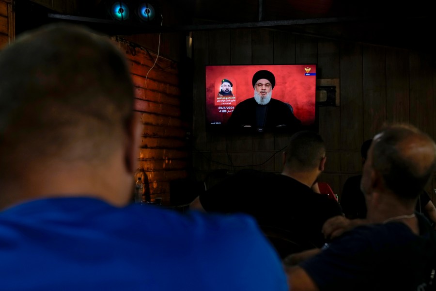 People listen to a speech by Hezbollah leader Sayyed Hassan Nasrallah broadcasted on Hezbollah's al-Manar television channel, at a coffee shop in a southern suburb of Beirut, Lebanon, Sunday, Aug. 25, 2024, hours after Israel and Hezbollah traded heavy fire. (AP Photo/Bilal Hussein)