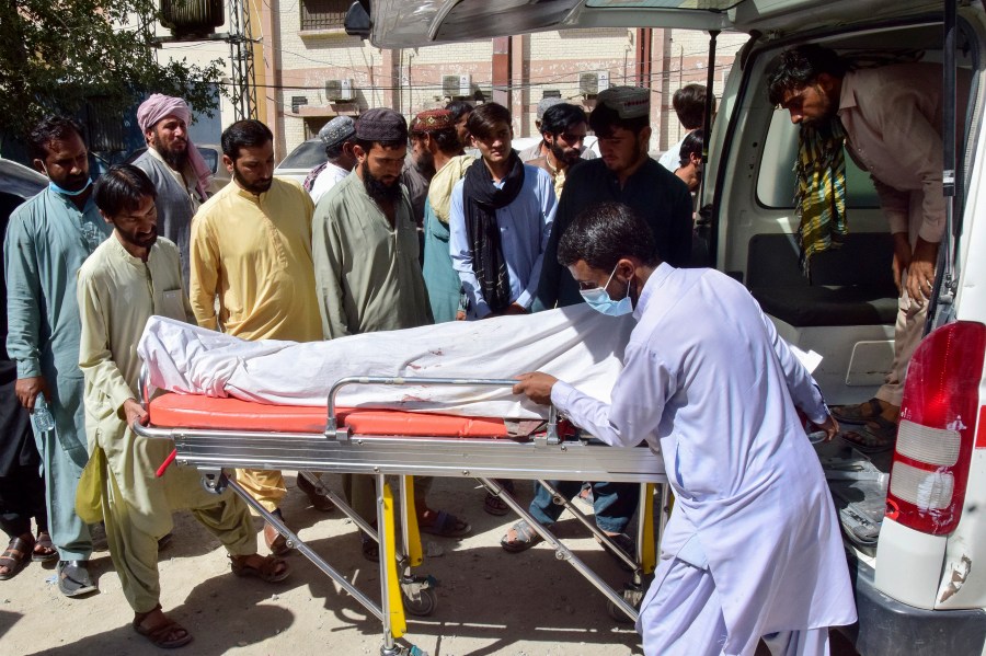 Volunteers and relatives load the body of a passenger, who was killed by gunmen at a highway in Musakhail, into an ambulance after collecting it from a hospital, in Quetta, Pakistan, Monday, Aug. 26, 2024. (AP Photo/Arshad Butt)