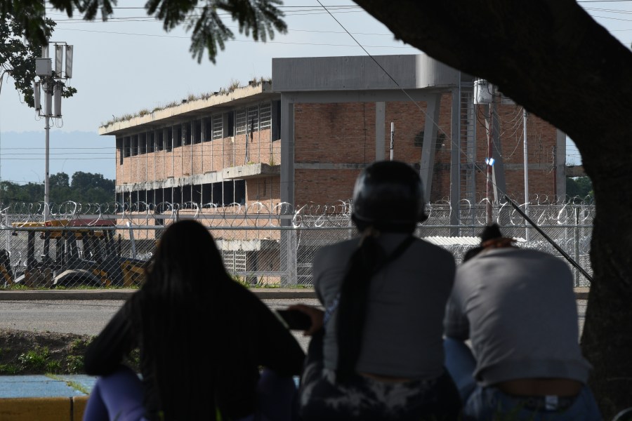 Relatives of detainees sit outside the Tocuyito jail as they protest against their arrests in Pocaterra, Venezuela, Monday, Aug. 26, 2024. The detainees were arrested while protesting against the results of the presidential election. (AP Photo/Jacinto Oliveros)