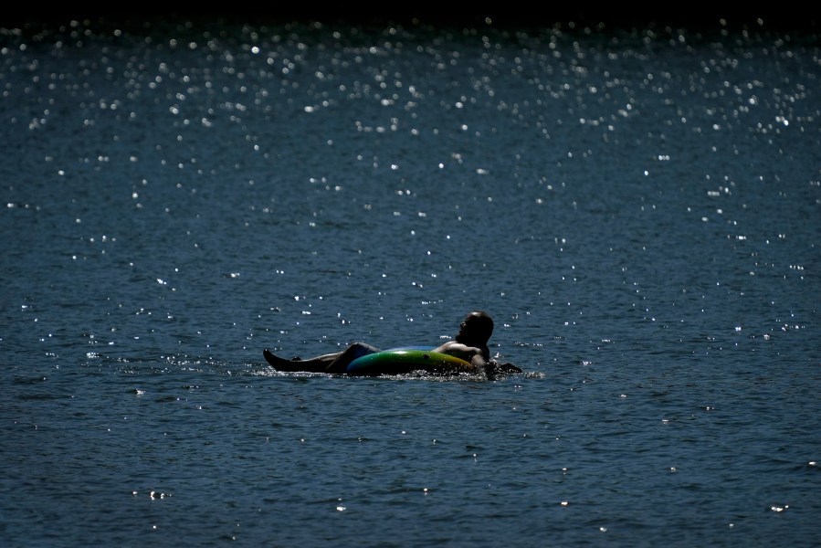 A tuber floats in the lake at Gray's Lake Park as the heat index tops 100 degrees, Monday, Aug. 26, 2024, in Des Moines, Iowa. (AP Photo/Charlie Neibergall)