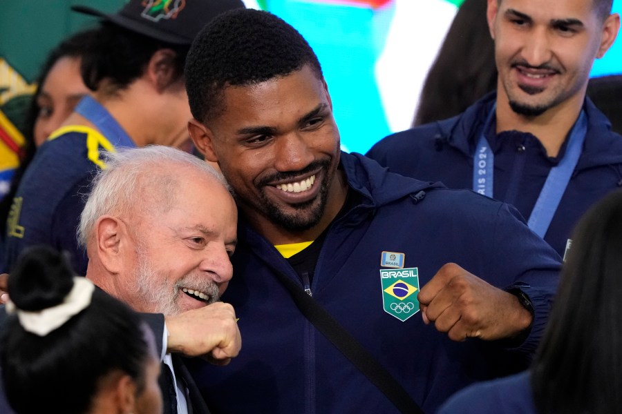 Brazil's President Luiz Inacio Lula da Silva, left, poses for a photo with boxer Abner Teixeira during a meeting with athletes who participated in the Paris Olympic Games, at the Planalto presidential palace, in Brasilia, Brazil, Monday, Aug. 26, 2024. (AP Photo/Eraldo Peres)