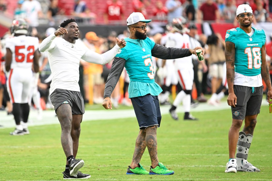 Miami Dolphins wide receivers Tyreek Hill, left, Odell Beckham Jr. (3) and Erik Ezukanma (18) stand of the field before a pre season NFL football game, Friday, Aug. 23, 2024, in Tampa, Fla. (AP Photo/Jason Behnken))