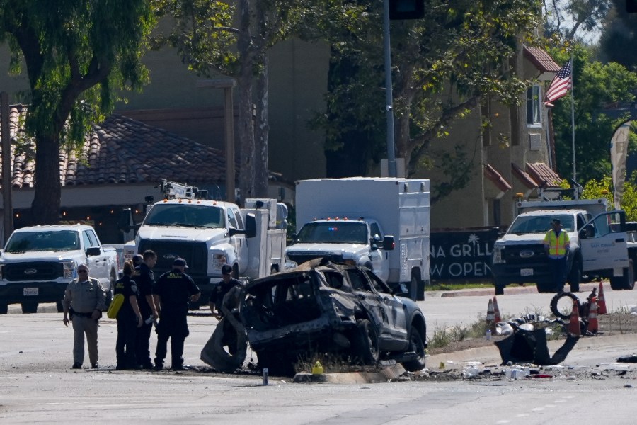 A charred police vehicle is seen in aftermath of an overnight crash which left an officer dead Tuesday, Aug. 27, 2024, in San Diego. (AP Photo/Gregory Bull)