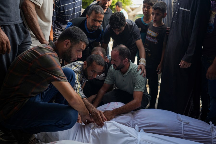 Palestinians mourn relatives killed in the Israeli bombardment of the Gaza Strip, at a hospital in Deir al-Balah, Tuesday, Aug. 27, 2024. (AP Photo/Abdel Kareem Hana)