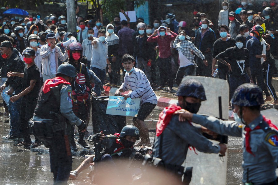 FILE - Protesters run after police shot warning shots and used water cannon to disperse them during a protest in Mandalay, Myanmar, Feb. 9, 2021. (AP Photo, File)