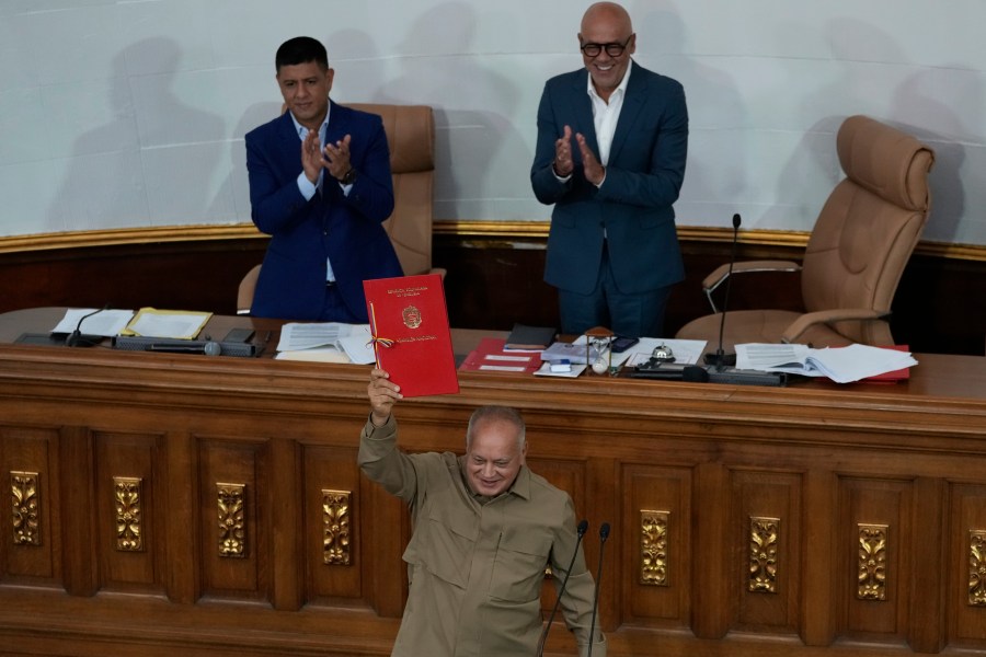 El primer vicepresidente de la Asamblea Nacional, Diosdado Cabello, sostiene un documento con la ley que regulará a las ONG, tras ser aprobada en una sesión en la Asamblea Nacional en Caracas, Venezuela, el jueves 15 de agosto de 2024. (AP Foto/Ariana Cubillos)