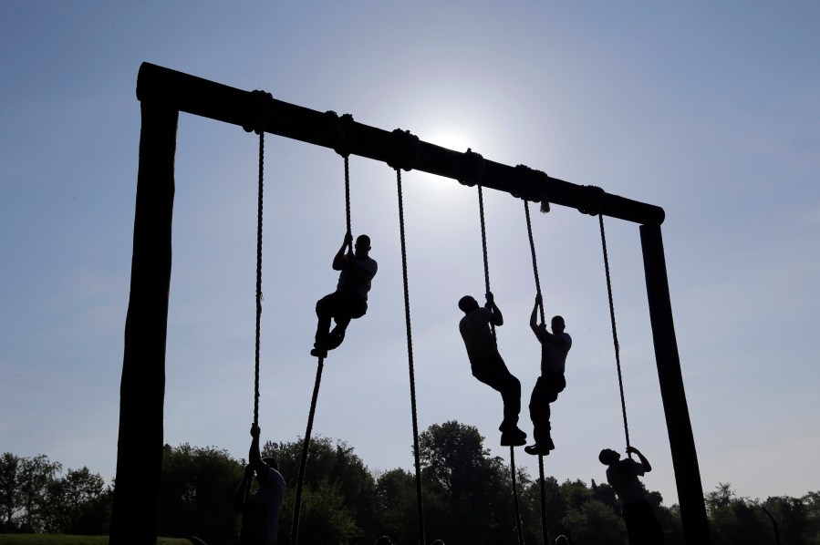 FILE - Freshman midshipmen, known as plebes, climb ropes on an obstacle course during Sea Trials, a day of physical and mental challenges that caps off the freshman year at the U.S. Naval Academy in Annapolis, Md., May 13, 2014. (AP Photo/Patrick Semansky, File)