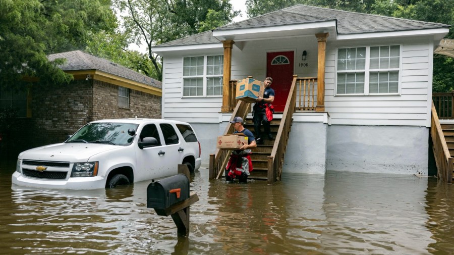 Savannah Fire Advanced Firefighters Ron Strauss, top, and Andrew Stevenson, below, carry food to residents in the Tremont Park neighborhood that where stranded in stormwater from Tropical Storm Debby, Tuesday, Aug. 6, 2024, in Savannah, Ga.