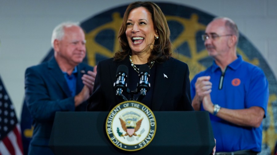 Democratic presidential nominee Vice President Kamala Harris, with Democratic vice presidential nominee Minnesota Gov. Tim Walz, left, and UAW President Shawn Fain, speaks at a campaign rally at UAW Local 900, Thursday, August 8, 2024, in Wayne, Mich.