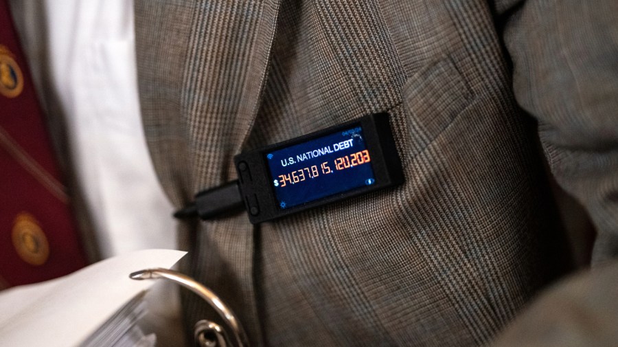 Rep. Thomas Massie (R-KY) wears a pin displaying the a live tally of the national debt during a House Committee on Rules business meeting at the U.S. Capitol on April 18, 2024 in Washington, DC. Speaker Mike Johnson (R-LA) is pushing aid to Ukraine, Israel and Taiwan through the House over the objections of the right-flank of his own party. (Photo by Kent Nishimura/Getty Images)