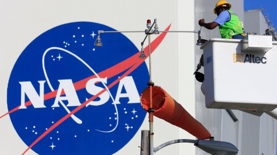 An electrician replaces bulbs near the Vehicle Assembly Building at the Kennedy Space Center, Fla. Thursday Nov. 13, 2008. Space Shuttle Endeavour is scheduled to lift-off Friday evening on a mission to the International Space Station. (AP Photo/Terry Renna)