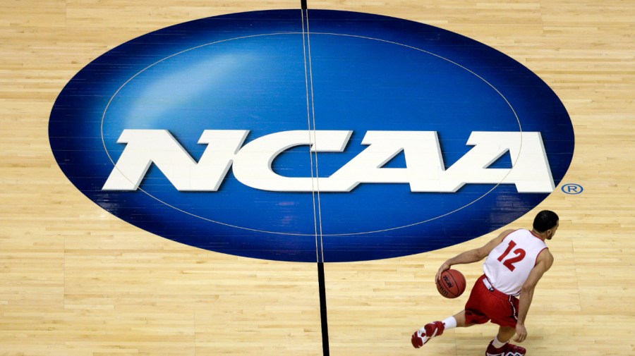 Wisconsin's Traevon Jackson dribbles past the NCAA logo during practice at the NCAA men's college basketball tournament March 26, 2014, in Anaheim, Calif. A federal judged has denied the first objection to a $2.77 billion settlement of antitrust lawuits facing the NCAA and five power conferences, ruling against Houston Christian University’s motion to intervene. (AP Photo/Jae C. Hong, File)