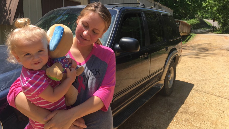 In this May 7, 2018, file photo, Mariah Kolka holds her daughter, Sophia, 1, outside her Linden, Tenn., home after meeting with advocates from an anti-poverty group, Save the Children. The Mass Poor People’s Assembly & Moral March on Washington aims to build upon the nation’s principles to pursue solutions to poverty — something advocates say is getting especially severe in rural areas. (AP Photo/Russell Contreras, File)